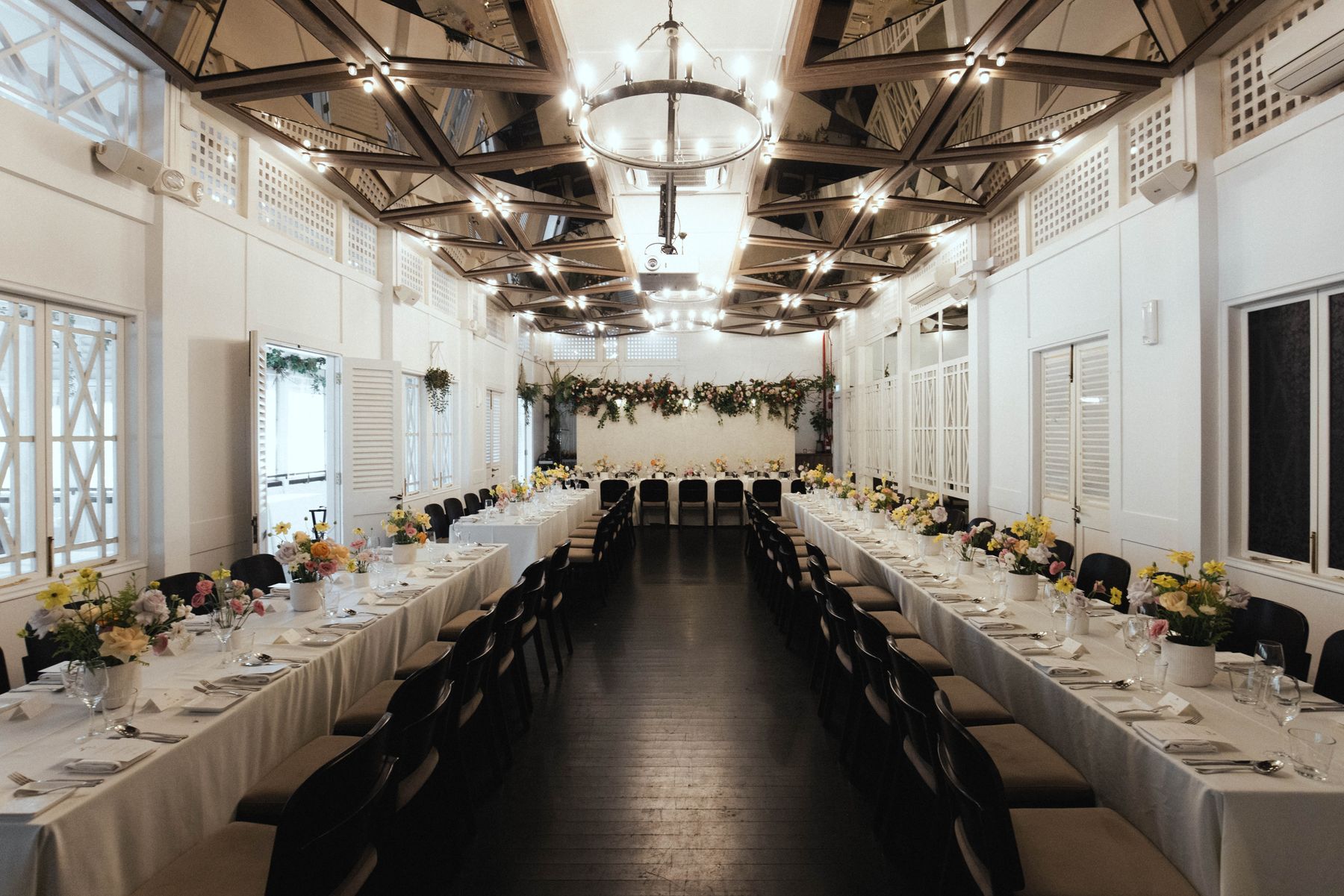 Long-table wedding reception set up in the Botanico indoor dining hall at The Summerhouse