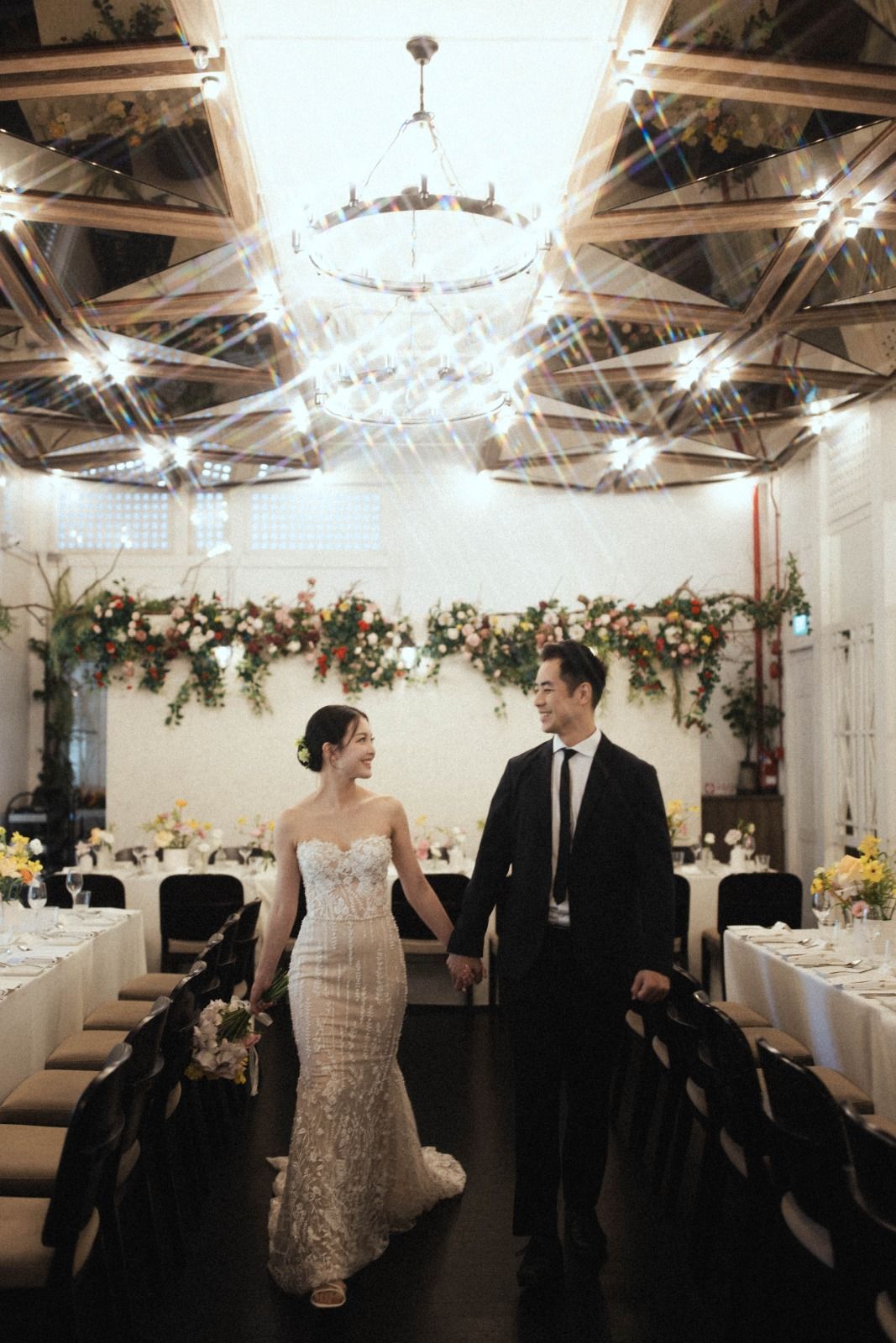 Bride and groom walking through the Botanico dining hall at their wedding reception at The Summerhouse