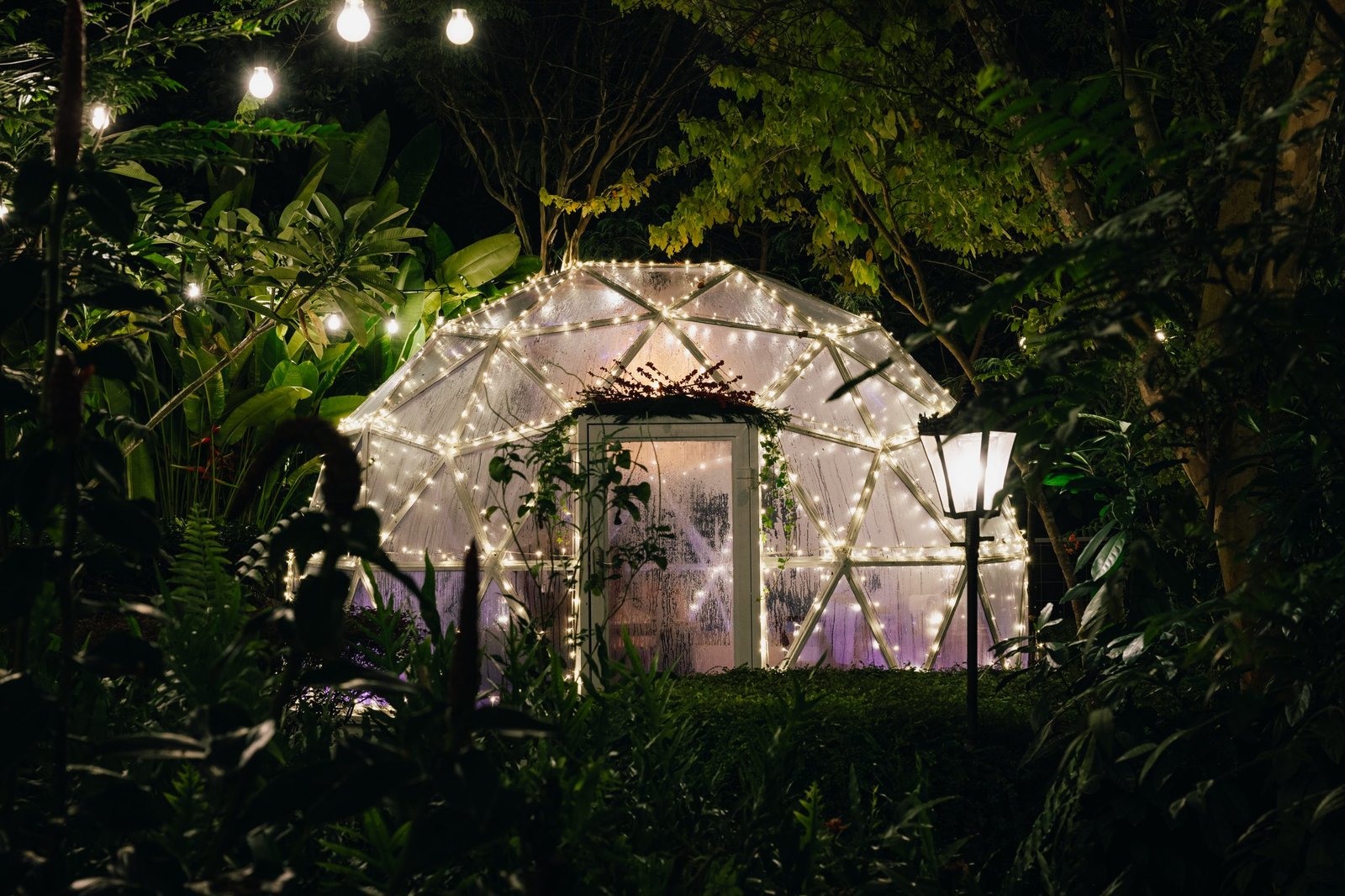 Glass Garden Domes glowing with fairy lights at night at The Summerhouse Seletar