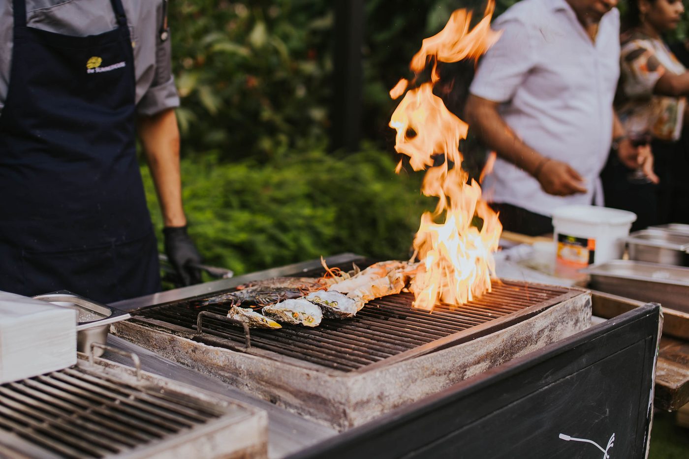 Live wood-charcoal grill flames at Wildseed Bar, The Summerhouse Seletar