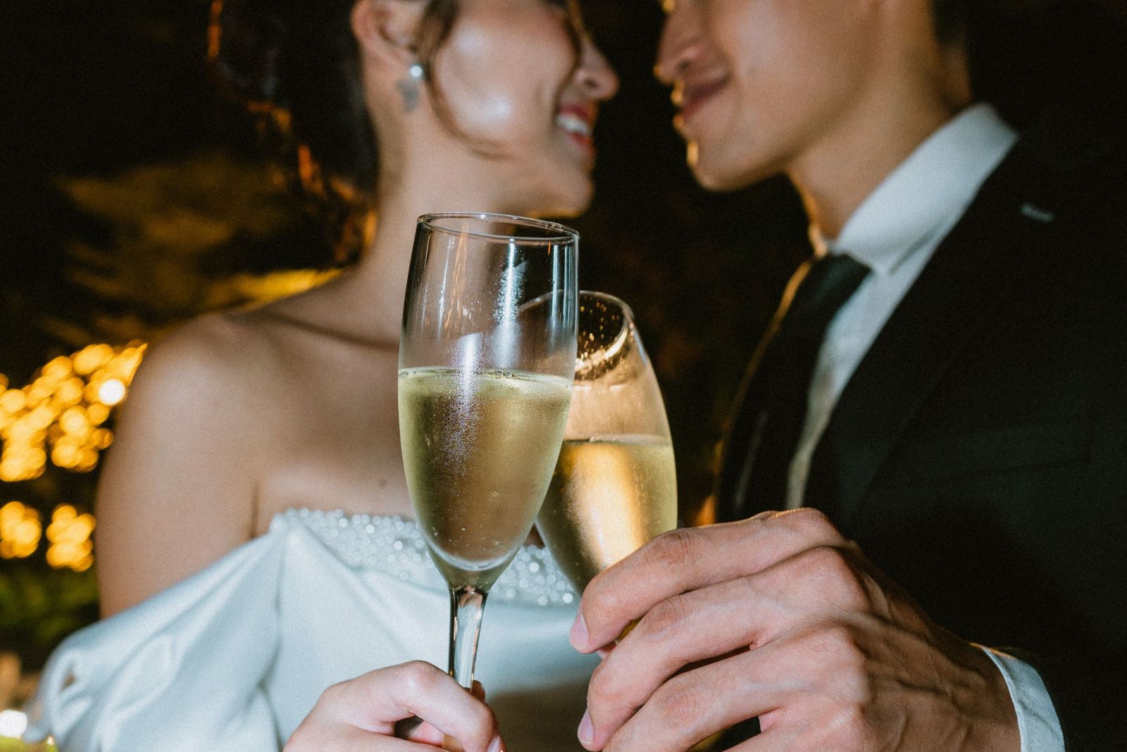 Bride and groom sharing a champagne toast at an evening wedding at The Summerhouse