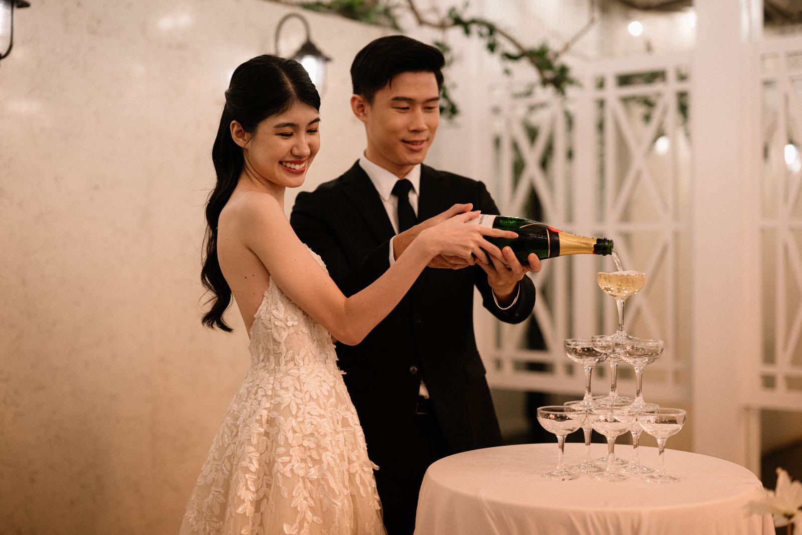 Bride and groom pouring a champagne tower at their wedding at The Summerhouse